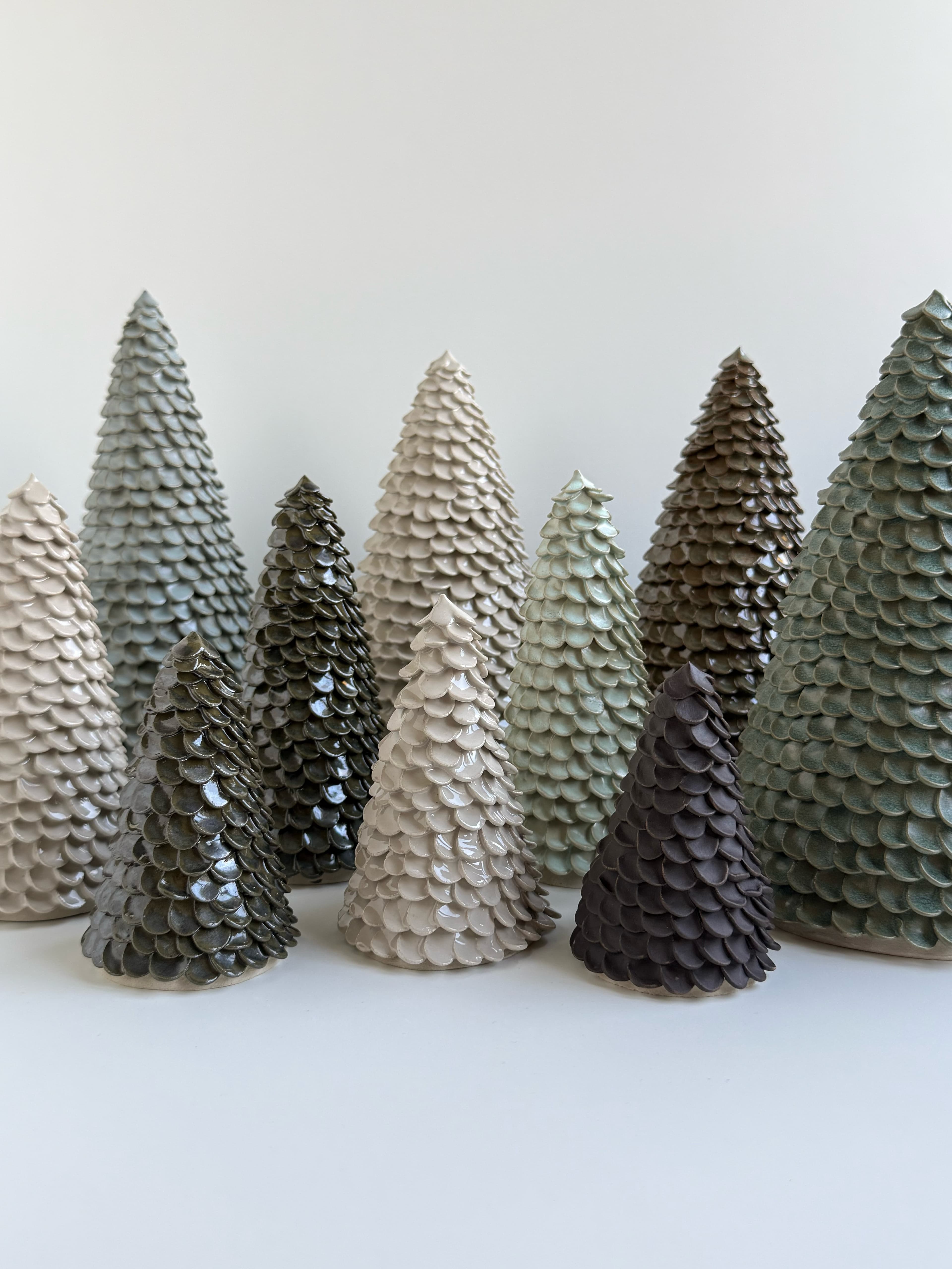 A group of CLÆY ceramic trees with overlapping branches in cream, pale green, grey and dark brown glazes